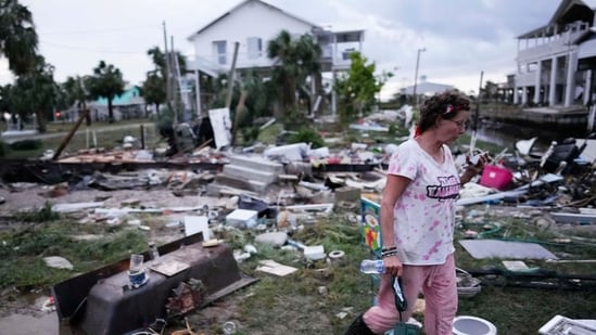 Jewell Baggett walks amidst debris strewn across the yard where her mother’s home had stood, as she searches for anything salvageable from the trailer home her grandfather had acquired in 1973 and built multiple additions on to over the decades, in Horseshoe Beach, Fla., after the passage of Hurricane Idalia, Wednesday, Aug. 30, 2023. (AP Photo/Rebecca Blackwell)