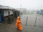 A woman walks on a flooded street as Storm Idalia makes landfall