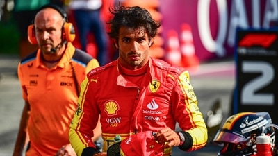 Ferrari's Spanish driver Carlos Sainz Jr (C) reacts after scoring pole position in the qualifying session, ahead of the Italian Formula One Grand Prix at Autodromo Nazionale Monza circuit (AFP)