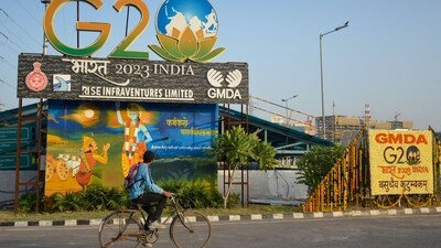 A man rides a bicycle past installations of the G20 Summit, (PTI) A man rides a bicycle past installations of the G20 Summit, (PTI)