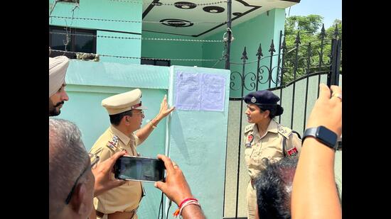 Cops outside the house of one the drug smuggling accused in Patiala on Saturday. (HT Photo)