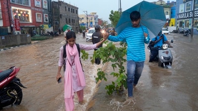 Commuters on a waterlogged road after heavy rains, in Bhubaneswar. (PTI) Commuters on a waterlogged road after heavy rains, in Bhubaneswar. (PTI)