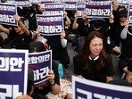 A South Korean teacher reacts as others chant slogans during a protest to demand better protection of their rights, the normalization of public education and to mourn a young teacher found dead in July in an apparent suicide, in Seoul, South Korea.
