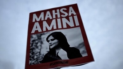 Iran Anti-Hijab Protests: A woman holds a placard with a picture of Iranian woman Mahsa Amini during a protest against her death. (AP)