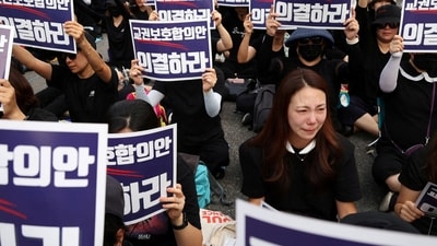A South Korean teacher reacts as others chant slogans during a protest to demand better protection of their rights, the normalization of public education and to mourn a young teacher found dead in July in an apparent suicide, in Seoul, South Korea. (Reuters)