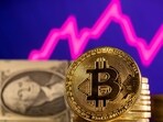 A representation of cryptocurrency bitcoin is seen in front of a stock graph and U.S. dollar in this illustration.