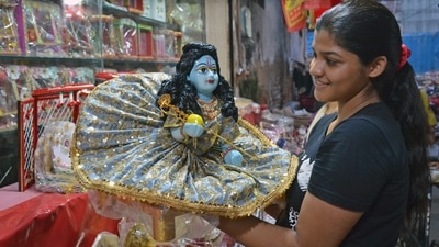 A woman looks at an idol of Lord Krishna at a shop ahead of Krishna Janmashtami in Gurugram. (ANI)