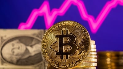 A representation of cryptocurrency bitcoin is seen in front of a stock graph and U.S. dollar in this illustration. (REUTERS)