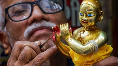 An artist gives final touches to a brass idol of Lord Krishna ahead of Krishna Janmashtami in Nagpur. (PTI)