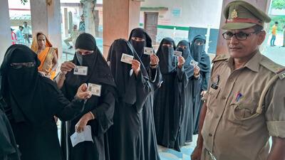 Voters show their IDs as they wait to cast their votes for the Ghosi assembly by-election, in Ghosi, on Tuesday. (PTI Photo)
