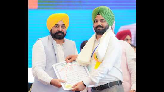 Punjab chief minister Bhagwant Mann felicitates a teacher at the state-level event in Moga on Tuesday. (HT photo)