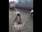 The image shows a cop cleaning a drain. The image shows a cop cleaning a drain.