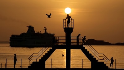 People wait to dive at the "bon secours" beach, as a heatwave hits France, in Saint-Malo, France, (Reuters)