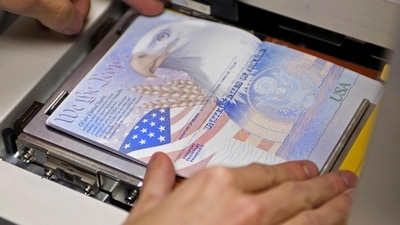 (FILES) A US government official with the State Department's Passport Services places a new blank US Passport with an embedded electronic chip into the "book printer," entering personal data and the photograph of an applicant on June 14, 2007, in Washington, DC. It is an "unprecedented demand", which comes up against the need to "rebuild" a service practically dismantled during covid, US Secretary od State Antony Blinken acknowledged, as travel surges post-Covid. The US State Department asked citizens to "check the expiration date of the document and renew it" as soon as possible before traveling. (AFP) (FILES) A US government official with the State Department's Passport Services places a new blank US Passport with an embedded electronic chip into the "book printer," entering personal data and the photograph of an applicant on June 14, 2007, in Washington, DC. It is an "unprecedented demand", which comes up against the need to "rebuild" a service practically dismantled during covid, US Secretary od State Antony Blinken acknowledged, as travel surges post-Covid. The US State Department asked citizens to "check the expiration date of the document and renew it" as soon as possible before traveling. (AFP)