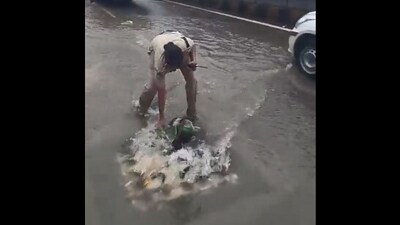 The image shows a cop cleaning a drain. (X/@HYDTP) The image shows a cop cleaning a drain. (X/@HYDTP)