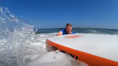 The image shows the swimmer saved by a surfer. (YouTube/Steve Houser) The image shows the swimmer saved by a surfer. (YouTube/Steve Houser)