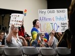 Parents, students, and staff of Chino Valley Unified School District hold up signs to protect LGBTQ+ policies at Don Antonio Lugo High School, on June 15, in Chino, Calif.