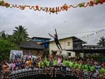 Hindu devotees help a man jump as he tries to reach the dahi-handi, curd-pot, suspended in the air above a water well during celebrations of Janmashtami. 