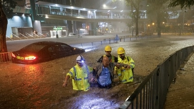 Drainage workers assist a driver stranded due to flooding to a safe place, during heavy rain in Hong Kong, China September 8. (REUTERS)