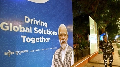 Indian security personnel stands guard next to a G20 communication billboard with a portrait of Prime Minister Narendra Modi days ahead of its commencement in New Delhi on September 7. (AFP) Indian security personnel stands guard next to a G20 communication billboard with a portrait of Prime Minister Narendra Modi days ahead of its commencement in New Delhi on September 7. (AFP)