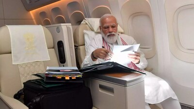 A file photo of PM Modi clearing official files in his official aircraft. A file photo of PM Modi clearing official files in his official aircraft.