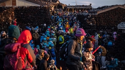 People gather after watching the sunrise from the summit of Mount Fuji, some 70 kilometres (43 miles) west of the capital Tokyo. Japanese authorities are gearing up to impose crowd control measures for the first time on Mount Fuji this weekend for an expected holiday rush by thousands of sometimes ill-prepared trekkers. (Photo by Philip FONG / AFP) People gather after watching the sunrise from the summit of Mount Fuji, some 70 kilometres (43 miles) west of the capital Tokyo. Japanese authorities are gearing up to impose crowd control measures for the first time on Mount Fuji this weekend for an expected holiday rush by thousands of sometimes ill-prepared trekkers. (Photo by Philip FONG / AFP)