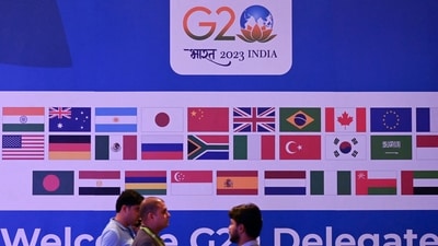 People walk past a banner with flags of countries participating in G20 summit at the International Media Center (IMC) at G20 venue on the eve of the two-day G20 summit in New Delhi on September 8, 2023. (Photo by TAUSEEF MUSTAFA / AFP) (AFP) People walk past a banner with flags of countries participating in G20 summit at the International Media Center (IMC) at G20 venue on the eve of the two-day G20 summit in New Delhi on September 8, 2023. (Photo by TAUSEEF MUSTAFA / AFP) (AFP)