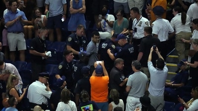 Police officers remove a climate change protester as play was halted. (Reuters)