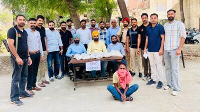 Punjab Police personnel with the 15-kg heroin consignment recovered from a tractor-trolley near Dhani Kharas Wali village in Fazilka district on Friday night. The smuggler driving the tractor was arrested, while two of his accomplices escaped. (HT Photo)