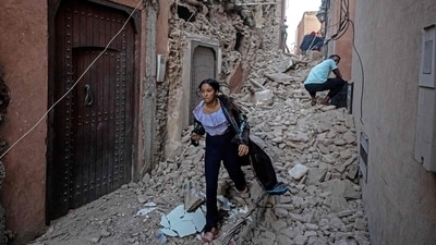A woman evacuates with her belongings through the rubble in the earthquake-damaged old city of Marrakesh on September 9. (AFP) A woman evacuates with her belongings through the rubble in the earthquake-damaged old city of Marrakesh on September 9. (AFP)