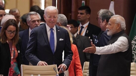 Prime Minister Narendra Modi points to US President Joe Biden his seat as they arrive for the first session of the G20 Summit in New Delhi.