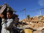 Morocco Earthquake: A person carries an item of furniture, in the aftermath of a deadly earthquake, in a hamlet on the outskirts of Talaat N'Yaaqoub, Morocco.