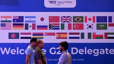 People walk past a banner with flags of countries participating in G20 summit at the International Media Center (IMC) at G20 venue on the eve of the two-day G20 summit in New Delhi on September 8, 2023. (Photo by TAUSEEF MUSTAFA / AFP) (AFP) People walk past a banner with flags of countries participating in G20 summit at the International Media Center (IMC) at G20 venue on the eve of the two-day G20 summit in New Delhi on September 8, 2023. (Photo by TAUSEEF MUSTAFA / AFP) (AFP)