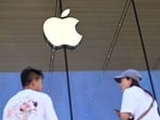 People stand outside an Apple store People stand outside an Apple store