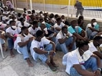 Newly arrived migrants wait to embark on a ferry to the mainland, in the Sicilian island of Lampedusa, Italy.