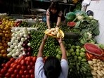 A woman buys vegetables at a market