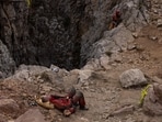 A rescuer rests at the entrance of Morca Cave as he takes part in a rescue operation to reach U.S. caver Mark Dickey who fell ill and became trapped some 1,000 meters (3,280 ft) underground, near Anamur in Mersin province, southern Turkey September 11, 2023