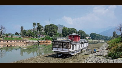 A houseboat on the dried riverbed of the Jhelum river in Srinagar on Tuesday. (Waseem Andrabi/HT) A houseboat on the dried riverbed of the Jhelum river in Srinagar on Tuesday. (Waseem Andrabi/HT)