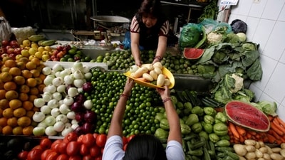 A woman buys vegetables at a market (REUTERS)