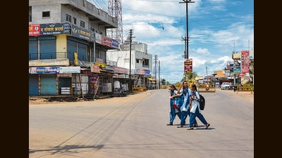 Schoolgirls walk on a deserted road after a clash between two groups over a controversial post on social media, at Pusesawali in Satara district on Monday. (PTI) Schoolgirls walk on a deserted road after a clash between two groups over a controversial post on social media, at Pusesawali in Satara district on Monday. (PTI)