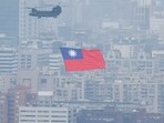 China-Taiwan Conflict: A Chinook helicopter carrying a Taiwan flag flies over the city during the country's National Day celebration in Taipei, Taiwan.