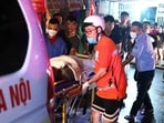 Rescue workers carrying victims following a major fire at an apartment block in Hanoi. (AFP)