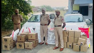 Police with the seized cartons of liquor in Pathankot on Wednesday. (HT photo)