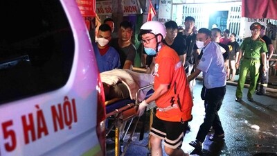 Rescue workers carrying victims following a major fire at an apartment block in Hanoi. (AFP)