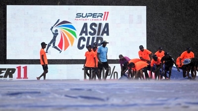Groundmen cover the pitch after as it rains at the R. Premadasa Stadium in Colombo (AFP)