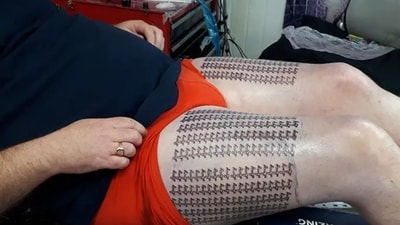 The image shows 'Lucy' inked 400 times on the man's thighs. (Guinness World Record) The image shows 'Lucy' inked 400 times on the man's thighs. (Guinness World Record)