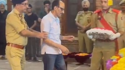 DSP Humayun Bhat's father Ghulam Hasaan Bhat, an ex-cop, laying a wreath on the mortal remains of his son.