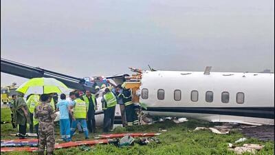 Officials gather around the damaged aircraft (PTI)