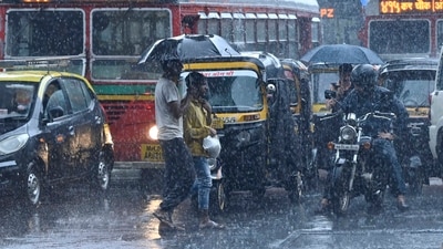 People crossing a road in a heavy monsoon rain at Andheri, in Mumbai, India. People crossing a road in a heavy monsoon rain at Andheri, in Mumbai, India.