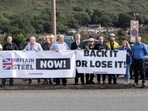 Protesters hold signs outside Tata Steel, on the day of a government announcement about steel industry investments, in Port Talbot, Britain September 15, 2023. REUTERS/Joann Randles